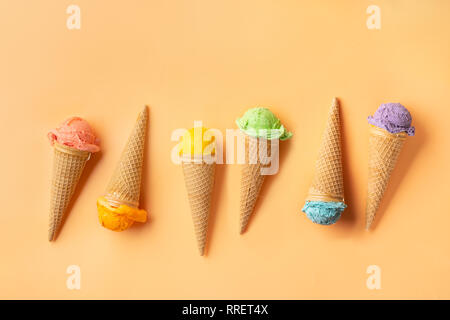 Vista dall'alto di colorati coni gelato su sfondo giallo. Concetto di estate Foto Stock