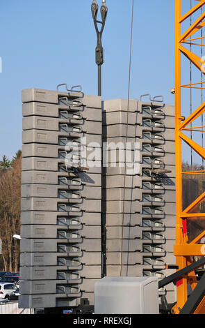 I blocchi di calcestruzzo con iscrizione 2500 kg come contatore elementi di equilibrio ad una gru da cantiere Foto Stock