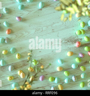 Colorate le uova di Pasqua decorate con strisce, fiori e macchie di colore blu, verde e giallo su verde sullo sfondo di legno con copia spazio per la vostra vacanza gre Foto Stock