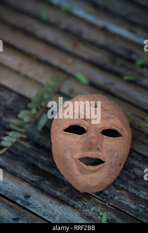 Maschera in terracotta su sfondi di bambù. Foto Stock