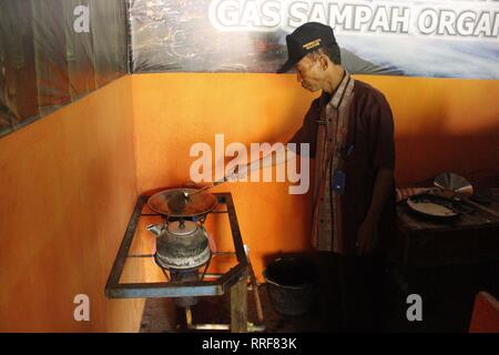 Madiun, Indonesia. Il 21 febbraio, 2019. Lavoratori rfi tempeh e cuocere l'acqua a bollire per preparare il caffè puro in polvere nella discarica Winongo area, Madiun città. Essi utilizzano i rifiuti organici come gas combustibile. Credito: Ajun alleato/Pacific Press/Alamy Live News Foto Stock