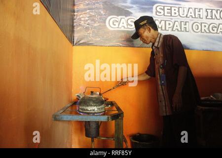 Madiun, Indonesia. Il 21 febbraio, 2019. Lavoratori rfi tempeh e cuocere l'acqua a bollire per preparare il caffè puro in polvere nella discarica Winongo area, Madiun città. Essi utilizzano i rifiuti organici come gas combustibile. Credito: Ajun alleato/Pacific Press/Alamy Live News Foto Stock