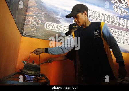 Madiun, Indonesia. Il 21 febbraio, 2019. Lavoratori rfi tempeh e cuocere l'acqua a bollire per preparare il caffè puro in polvere nella discarica Winongo area, Madiun città. Essi utilizzano i rifiuti organici come gas combustibile. Credito: Ajun alleato/Pacific Press/Alamy Live News Foto Stock