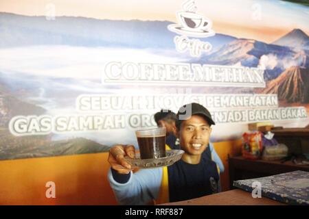 Madiun, Indonesia. Il 21 febbraio, 2019. Lavoratori rfi tempeh e cuocere l'acqua a bollire per preparare il caffè puro in polvere nella discarica Winongo area, Madiun città. Essi utilizzano i rifiuti organici come gas combustibile. Credito: Ajun alleato/Pacific Press/Alamy Live News Foto Stock