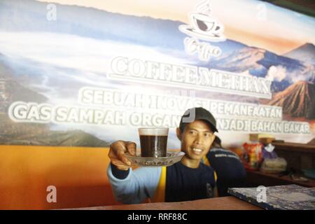 Madiun, Indonesia. Il 21 febbraio, 2019. Lavoratori rfi tempeh e cuocere l'acqua a bollire per preparare il caffè puro in polvere nella discarica Winongo area, Madiun città. Essi utilizzano i rifiuti organici come gas combustibile. Credito: Ajun alleato/Pacific Press/Alamy Live News Foto Stock