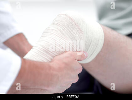 Closeup. medico del bendaggio una gamba del paziente Foto Stock