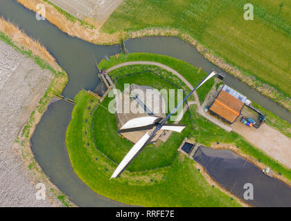 Tipico mulino a vento olandese del XVII secolo il colpo da sopra con un drone circondata da un canale nei campi dell'Olanda Foto Stock