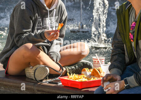 LAS VEGAS, NEVADA, STATI UNITI D'AMERICA - Febbraio 2019: due giovani seduti a mangiare fast food da un contenitore in plastica in Las Vegas. Foto Stock