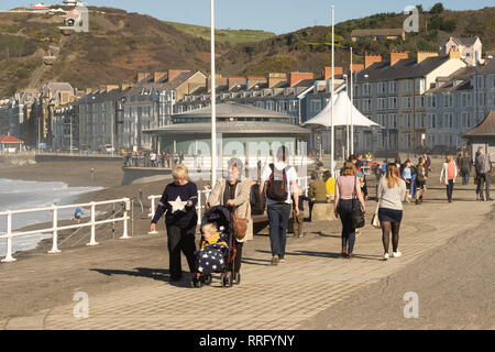 Aberystwyth Ceredigion Wales UK, martedì 26 febbraio 2019. Regno Unito Meteo: la gente sulla spiaggia e il lungomare di Aberystwyth - La scuola durante il termine di metà settimana in Galles - rendendo la maggior parte dell'incredibilmente caldo e soleggiato . Ieri la zona circostante il paese conobbe il più caldo mai recored febbraio le temperature nel Regno Unito, raggiungendo 20,3 ºC a Trawsgoed circa 5 miglia di navigazione Photo credit: keith morris/Alamy Live News Foto Stock