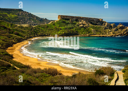 Malta Riviera beach, Mgarr. Ghajn Tuffieha Bay con sabbia dorata. Mare Mediterraneo paesaggio lagunare Foto Stock