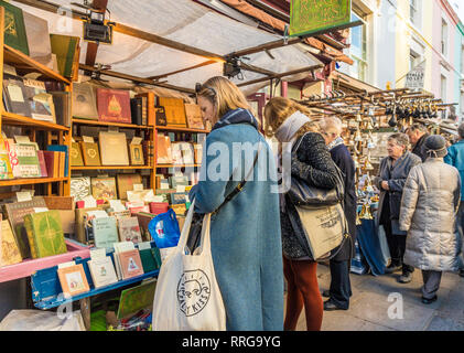 La gente in un antico libro in stallo al Mercato di Portobello Road a Notting Hill, Londra, Inghilterra, Regno Unito, Europa Foto Stock