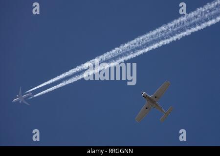 Come un aereo vola in cielo si lascia un percorso contrail nel suo passato. Foto Stock