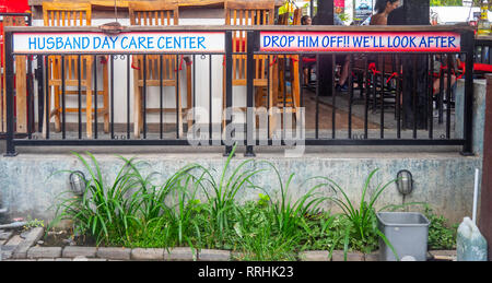 Segno umoristico al di fuori di un bar in Kuta Bali Indonesia. Foto Stock