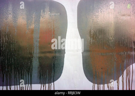 L'acqua di condensazione forme di smorzare le finestre e le tracce di acqua e ruscelletti sul foglio di un grigio chiuso rimorchio. Foto Stock