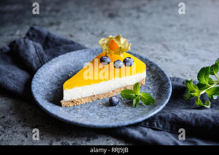 In casa non cuocere mango cheesecake decorate con mirtilli e physalis Foto Stock