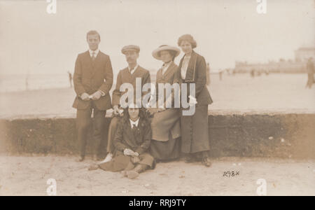 Cartolina fotografica che mostra una famiglia in posa su una spiaggia del Kent. Eventualmente Cliftonville. Foto Stock