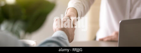 Chiudere l'immagine orizzontale maschio femmina imprenditori stringono le mani Foto Stock