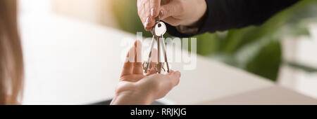 L'immagine orizzontale close up mani maschio che dà le chiavi a femmina Foto Stock