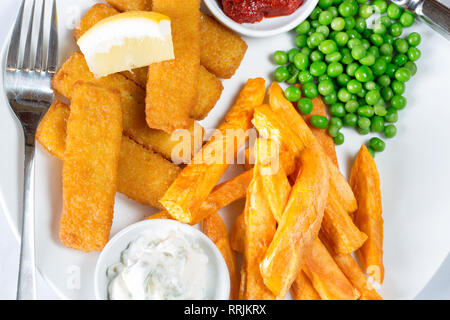 Classico pub inglese il pranzo di pesce dita, patatine e piselli giardino servito con fatti in casa ketchup, salsa tartara e limone fresco cuneo. Foto Stock