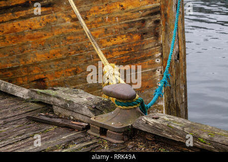 Bollard e linee di ormeggio per una vecchia nave di legno. Da una delle banchine interne in Solheimsviken Bay, Bergen, Norvegia Foto Stock