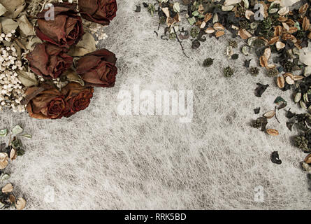 Sfondo romantico in tenui colori autunnali con la rosa appassita e pot pourri su bianco carta di riso Foto Stock