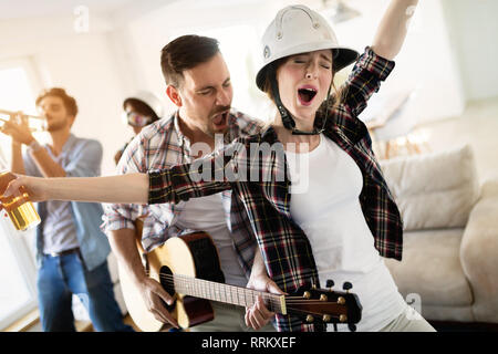 Gruppo di amici a suonare la chitarra e di festa a casa Foto Stock