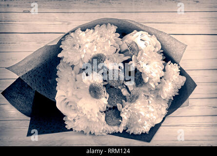 Bouquet di rose e crisantemi in imballaggi decorativi. Foto Stock
