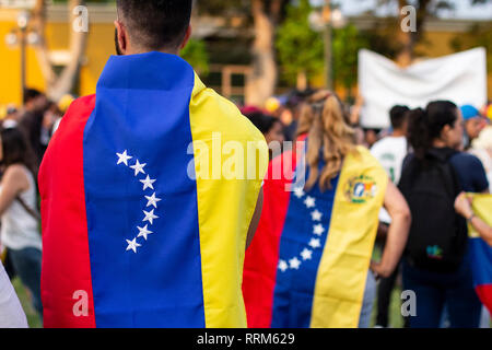 Lima in Perù - 2 Febbraio 2019: la gente avvolta nella bandiera venezuelana a protestare contro Nicolas Maduro Foto Stock