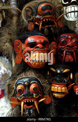 Un set di maschere in legno balinese fatte a mano in un negozio di souvenir tradizionale. Foto Stock