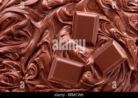Close up di cioccolato fuso e pezzi di barra di cioccolato Foto Stock