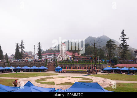 Il mercato esterno nel campo di grandi dimensioni dalla Nhà Thờ Đá Sapa o la cattedrale di Notre Dame in un giorno nuvoloso, Sa Pa, Vietnam Foto Stock