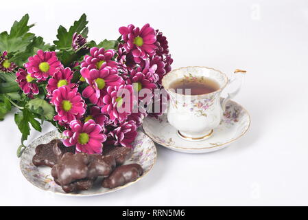 Impostazione tabella, mazzo di fiori, tè e biscotti Foto Stock