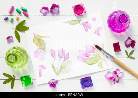 Vernici ad acquerello, pennelli per pittura, pastello pastelli, rosa fiori viola e acquerello sketch. Vista dall'alto. Lay piatto. Foto Stock