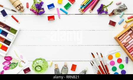 Vernici ad acquerello, pennelli per pittura, matite, il pastello su tavola bianco. Vista dall'alto. Lay piatto. Foto Stock