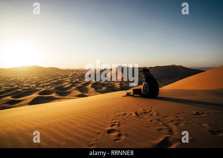 Viaggiatore maschio godendo di sunny sandy desert view, Sahara, Marocco Foto Stock