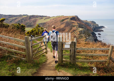 Due persone che camminano sulla costa sud ovest percorso e Tarka sentiero verso il punto di Bull da Lee Bay, Ilfracombe, North Devon, Inghilterra, Regno Unito, Gran Bretagna Foto Stock