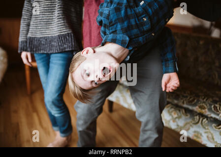 Giocoso ragazzo appeso a testa in giù Foto Stock