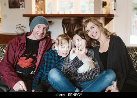 Ritratto di famiglia felice con la guinea pig sul divano Foto Stock