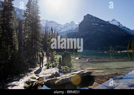 Le donne escursioni lungo la tranquilla, idilliaco lago di montagna Foto Stock