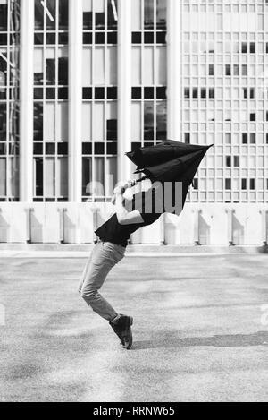 L'uomo ballando con ombrello testa di copertura Foto Stock