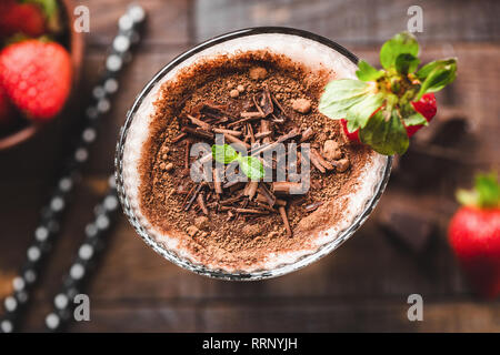 Frullato al cioccolato in vetro in primo piano. Dark frullato al cioccolato o protein shake. Messa a fuoco selettiva Foto Stock