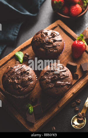 Dark Chocolate muffin su tavola di legno, vista dall'alto, tonica immagine. Gustosa torta al cioccolato Foto Stock