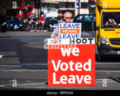 Lasciare Brexit sostenitore sorge nel traffico vicino Piazza del Parlamento nel centro di Londra chiedendo sostenitori per sparare le loro corna a sostegno Foto Stock