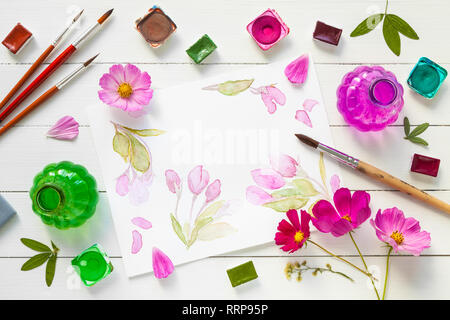 Vernici ad acquerello, pennelli per pittura, fiori di colore rosa e acquerello sketch. Vista dall'alto. Lay piatto. Foto Stock