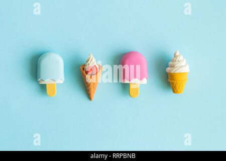 Piatto di laici miniatura gelato isolato sul pastello blu sullo sfondo il minimo concetto creativo. Foto Stock