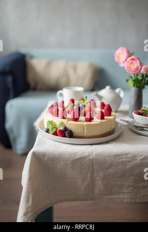 Non affettato cuocere Strawberry Cheesecake decorate con fragole fresche e di lampone e menta. Concetto di vacanza dolce cibo Foto Stock