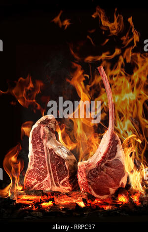 Un top bistecca di controfiletto arrostito alla fiamma su un barbecue, una profondità di campo ridotta. carne sul tessuto osseo nel fuoco Foto Stock