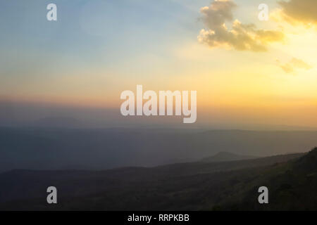 In stile vintage di astratta campo sfocatura su orange bokeh luce Autunno in montagna e giovane fotografo guardando paesaggi durante il golden ora sun rise ba Foto Stock