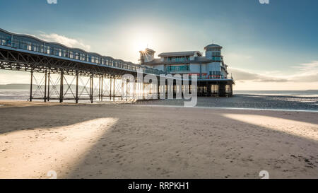 Weston-super-Mare, North Somerset, Inghilterra, Regno Unito - Ottobre 04, 2018: il sole al tramonto sulla spiaggia e il Grand Pier Foto Stock