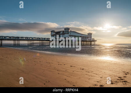 Weston-super-Mare, North Somerset, Inghilterra, Regno Unito - Ottobre 04, 2018: il sole al tramonto sulla spiaggia e il Grand Pier Foto Stock